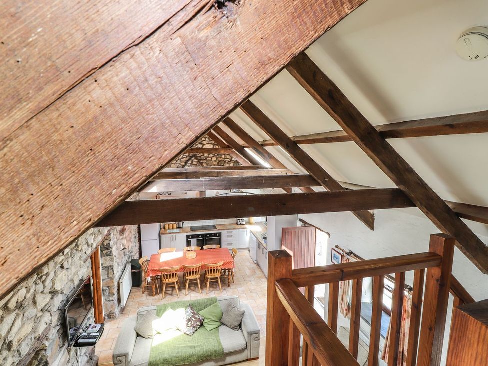 A living room with wooden beams and a dining area at Ty Felin Newport