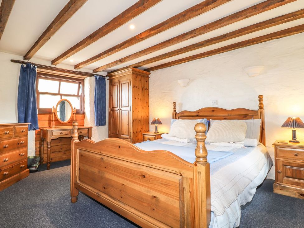 A bedroom with wooden furniture and a window at Ty Felin Newport
