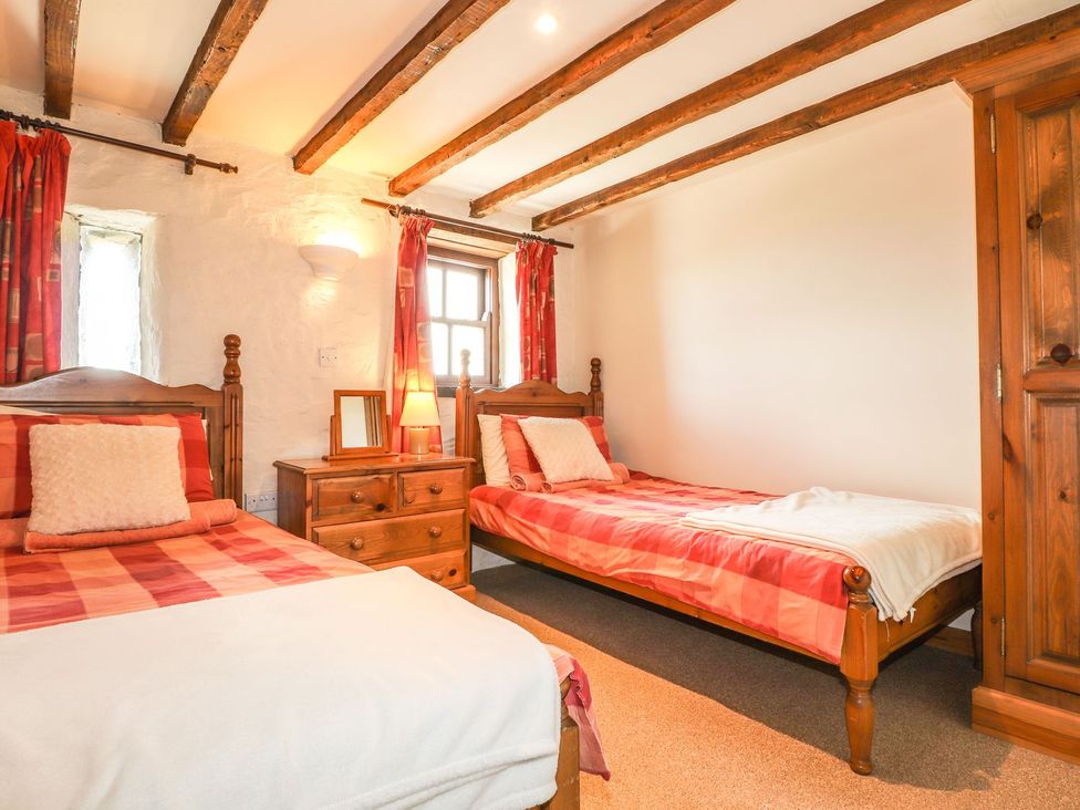 A bedroom with two beds and a nightstand at Ty Felin Newport
