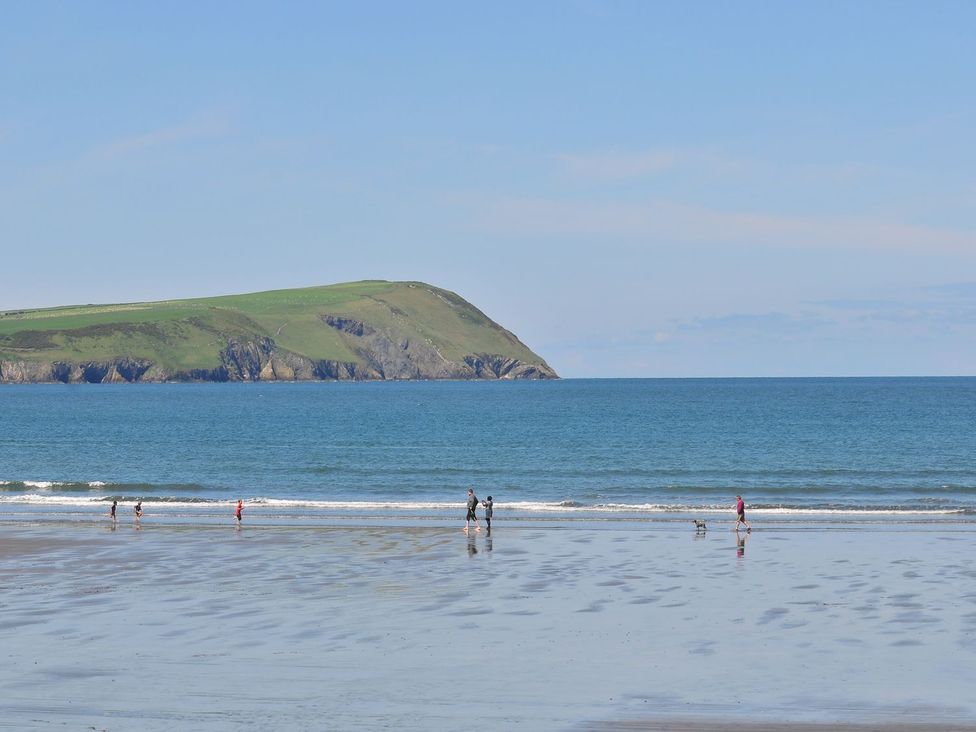 People walking on the beach with hills in the background at Ty Felin Newport