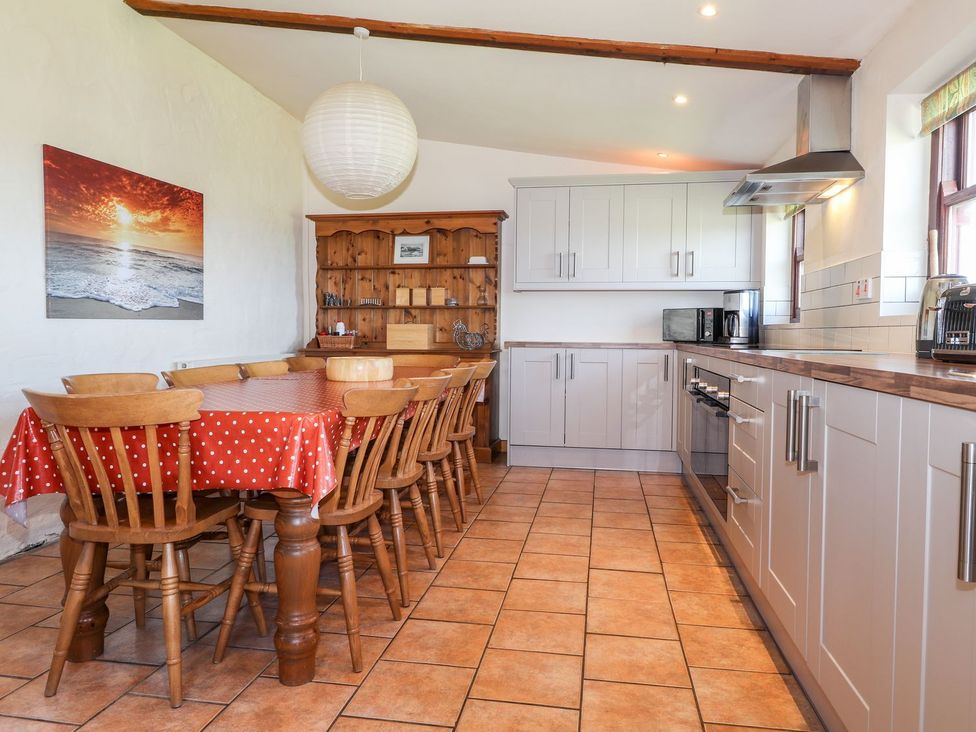 A kitchen with a dining table and chairs at Ty Gwartheg in Newport