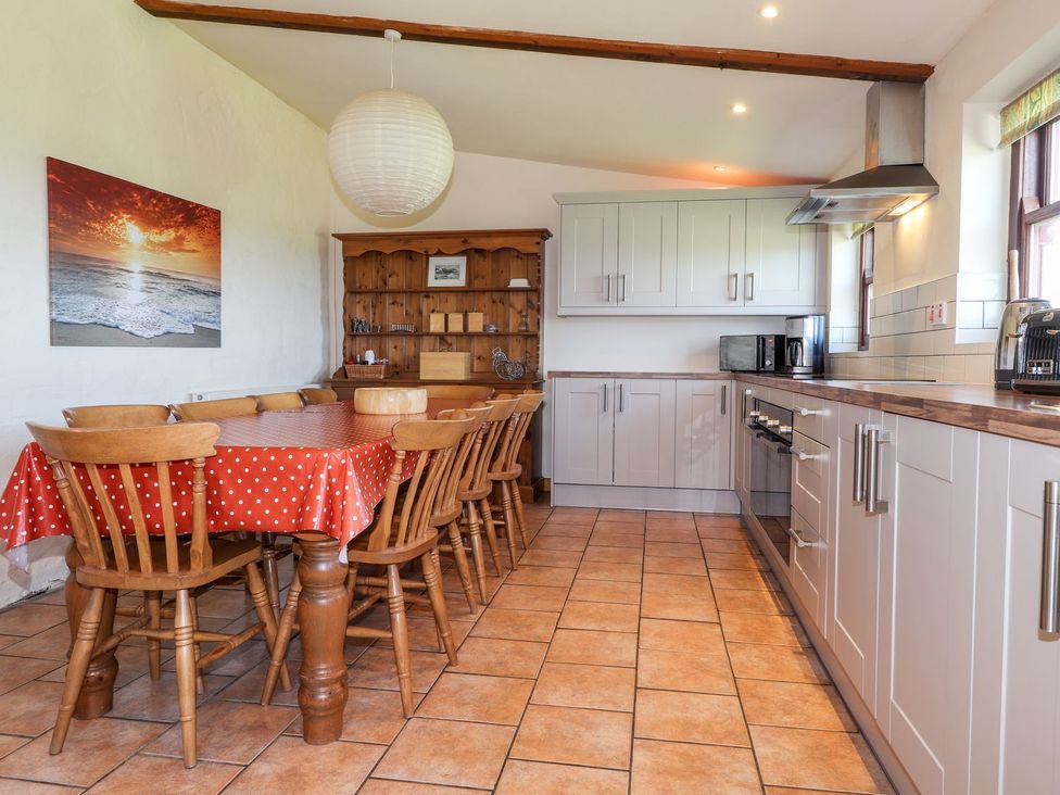 A kitchen with a dining table and chairs at Ty Gwartheg Newport