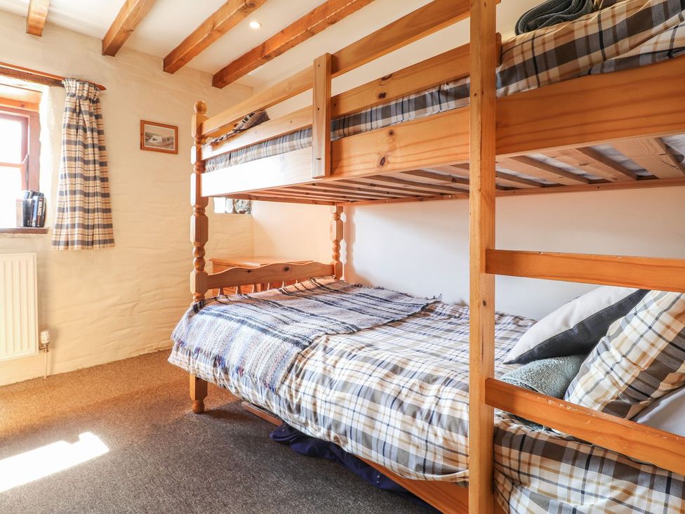 A bedroom with a bunk bed and a window at Ty Gwartheg in Newport