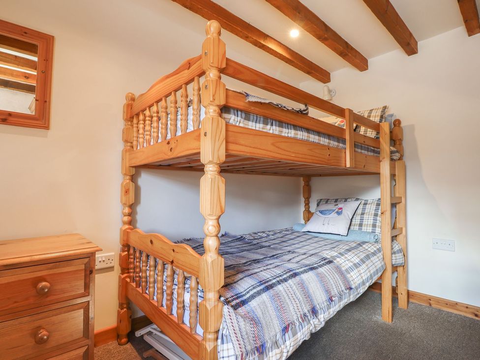 A bedroom with a bunk bed and a chest of drawers at Ty Gwartheg Newport