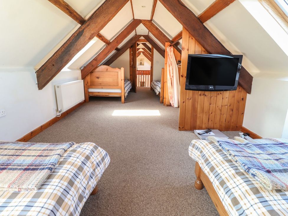 A loft with beds and a television at Ty Gwartheg in Newport