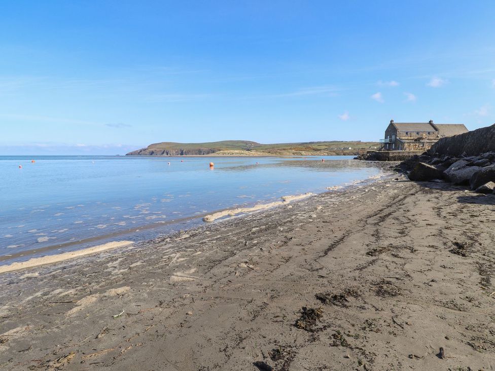 A beach with water and a house in the background at Ty Gwartheg Newport