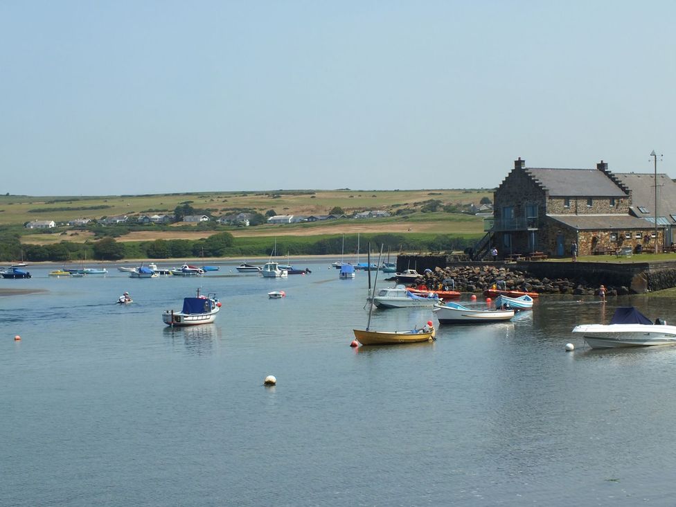 A marina with boats and a building at Ty Cariad in Newport