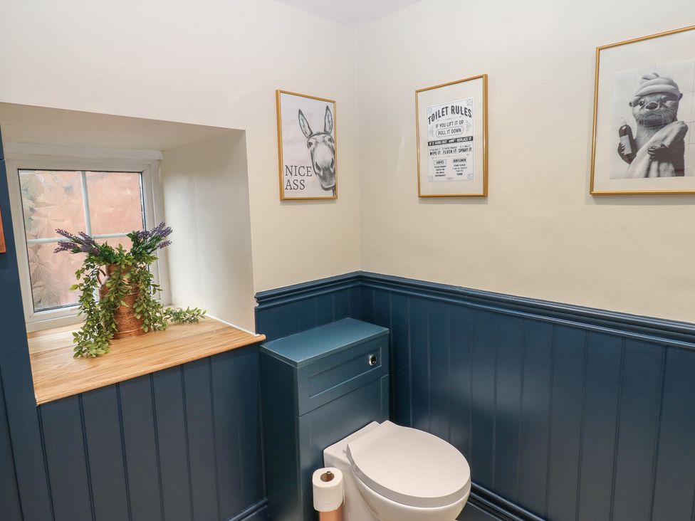 A bathroom with a toilet and wall art at Broadwath Old House in Heads Nook