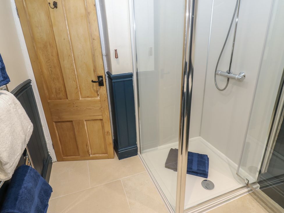 A bathroom with a shower and towels at Broadwath Old House in Heads Nook