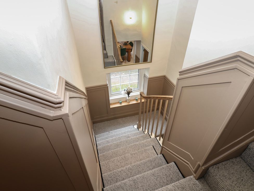 A staircase with a mirror and window at Broadwath Old House in Heads Nook