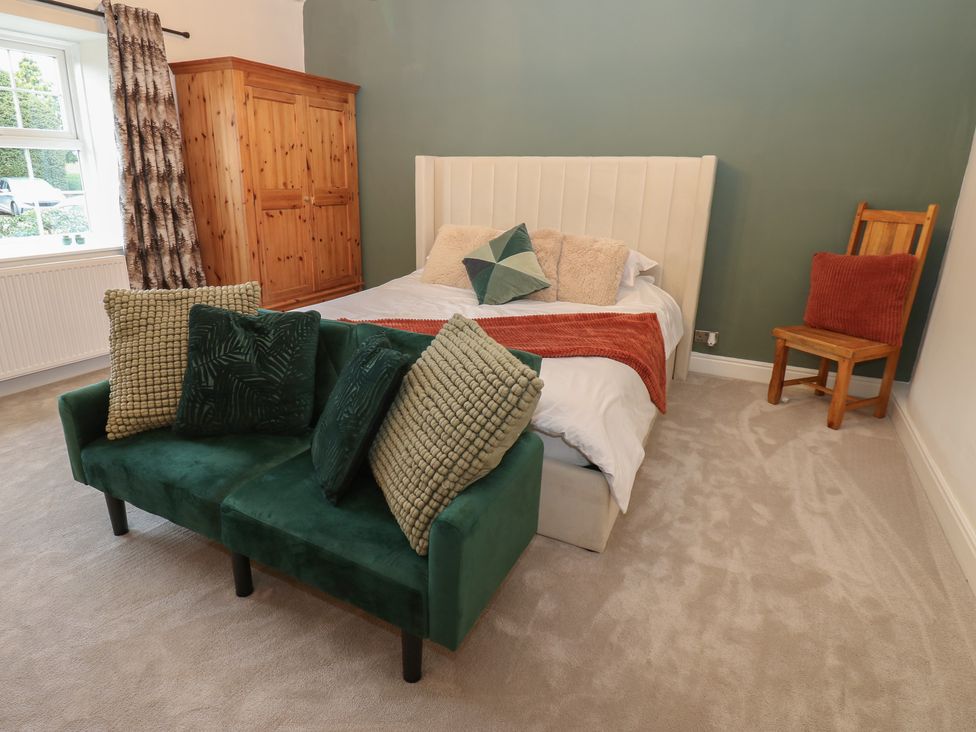 A bedroom with a bed and wardrobe at Broadwath Old House in Heads Nook