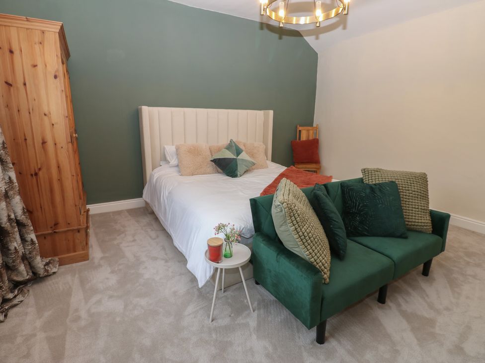A bedroom with a bed and armchair at Broadwath Old House in Heads Nook