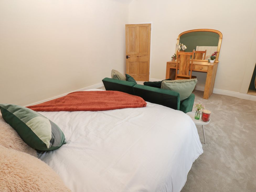 A bedroom with a bed and a table at Broadwath Old House in Heads Nook