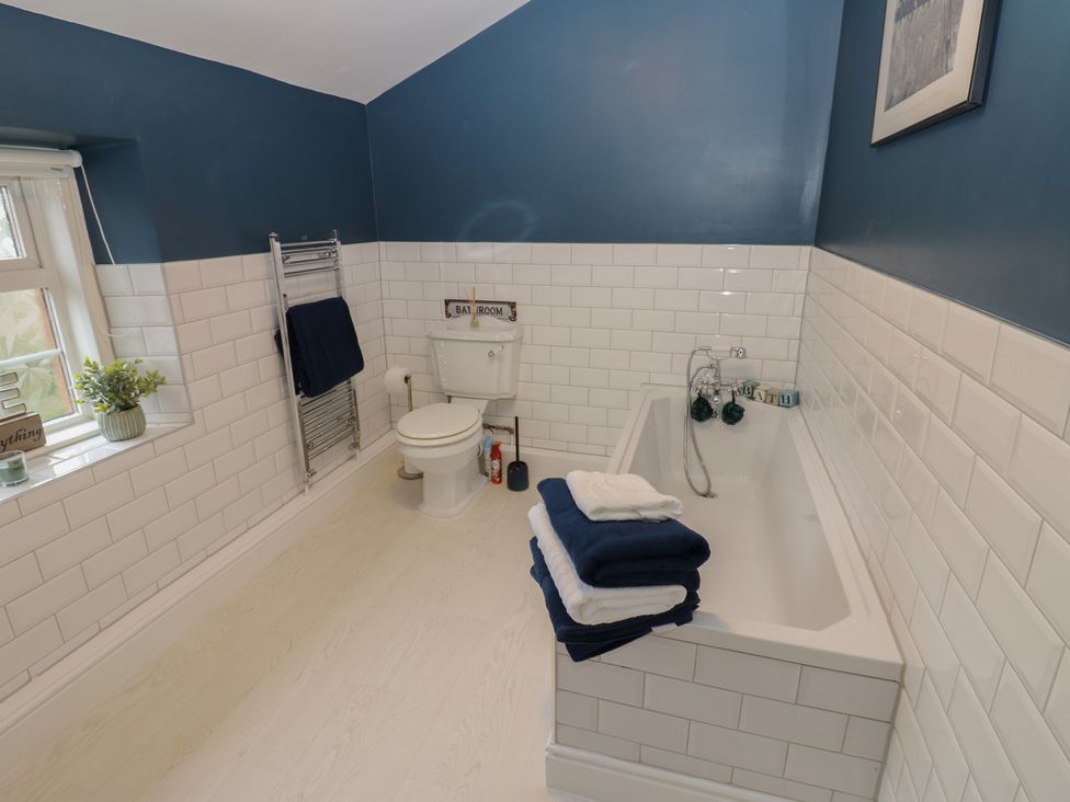 A bathroom with a toilet and bath tub at Broadwath Old House in Heads Nook