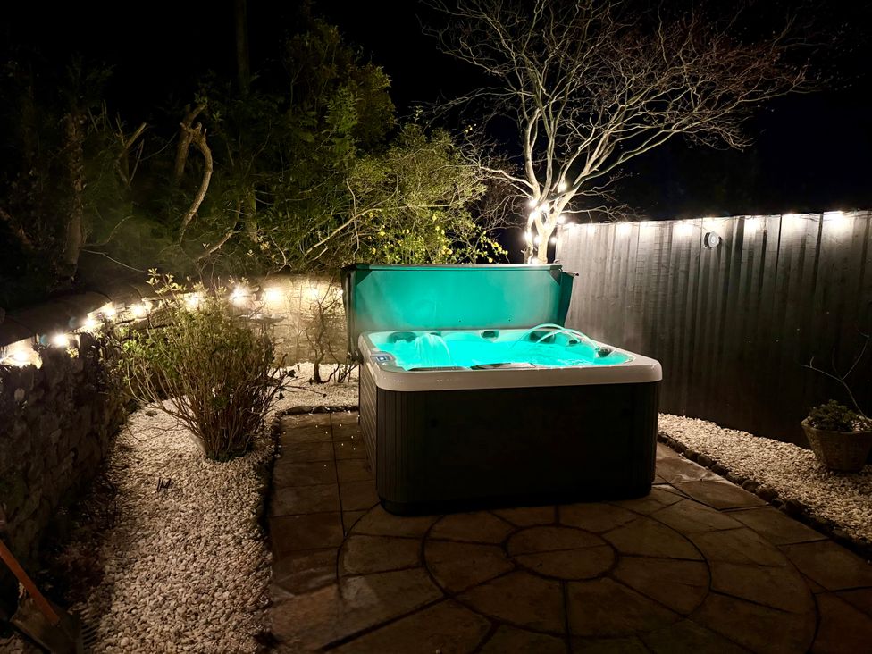 A hot tub surrounded by plants and light fixtures at Broadwath Old House near Corby Hill