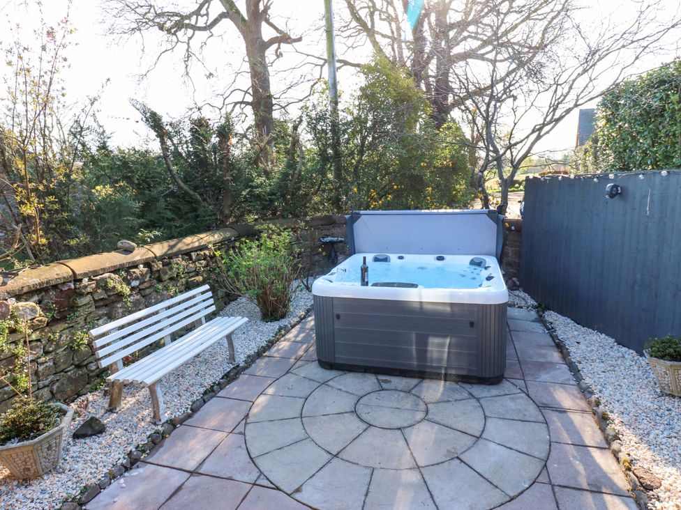 A garden with a hot tub and a bench at Broadwath Old House Broadwath near Corby Hill