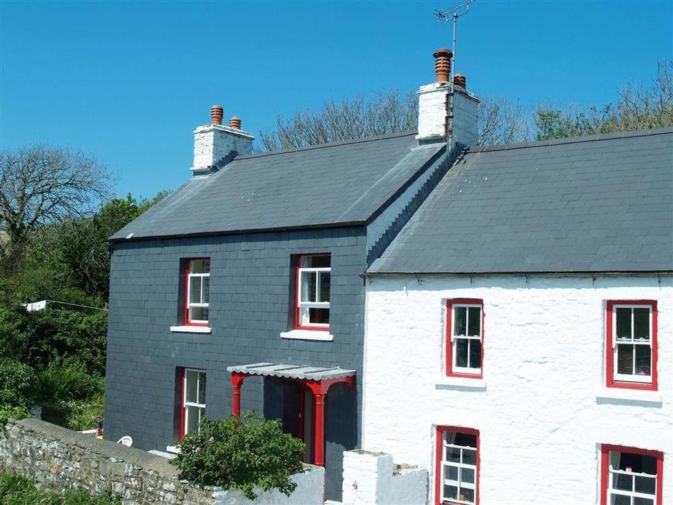 A house with a black and white exterior at Dinas Island Cottage Dinas Cross