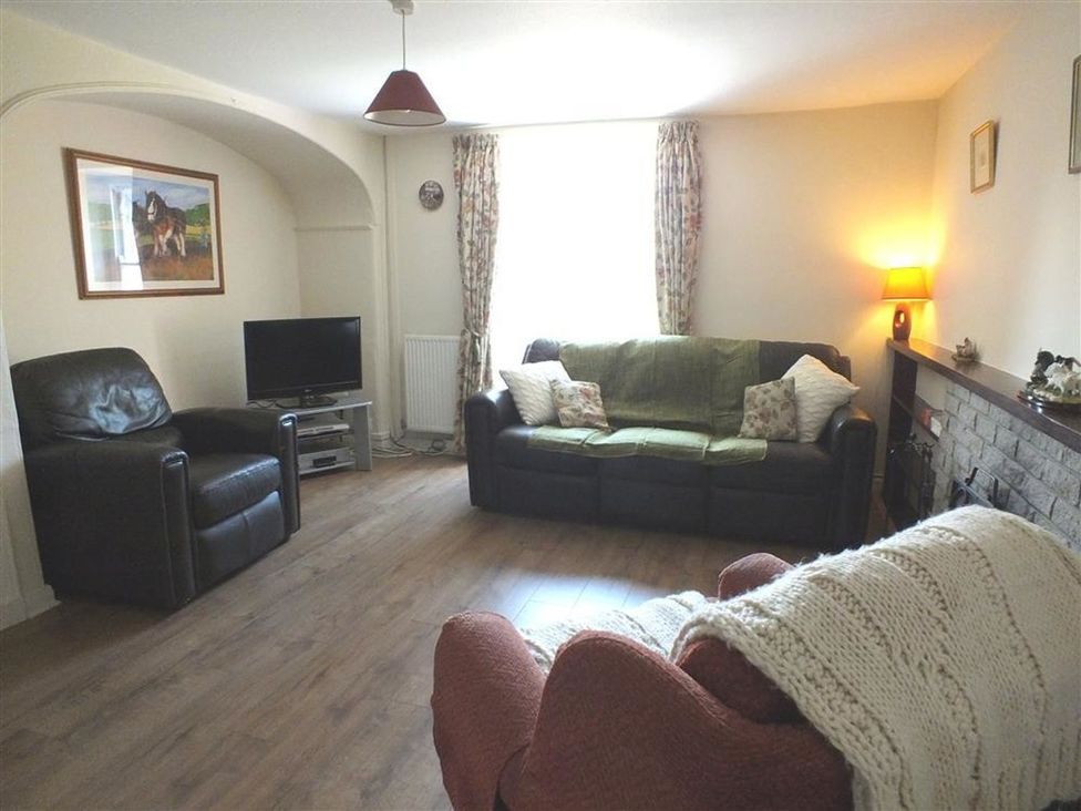 A living room with a sofa and armchairs at Dinas Island Cottage in Dinas Cross