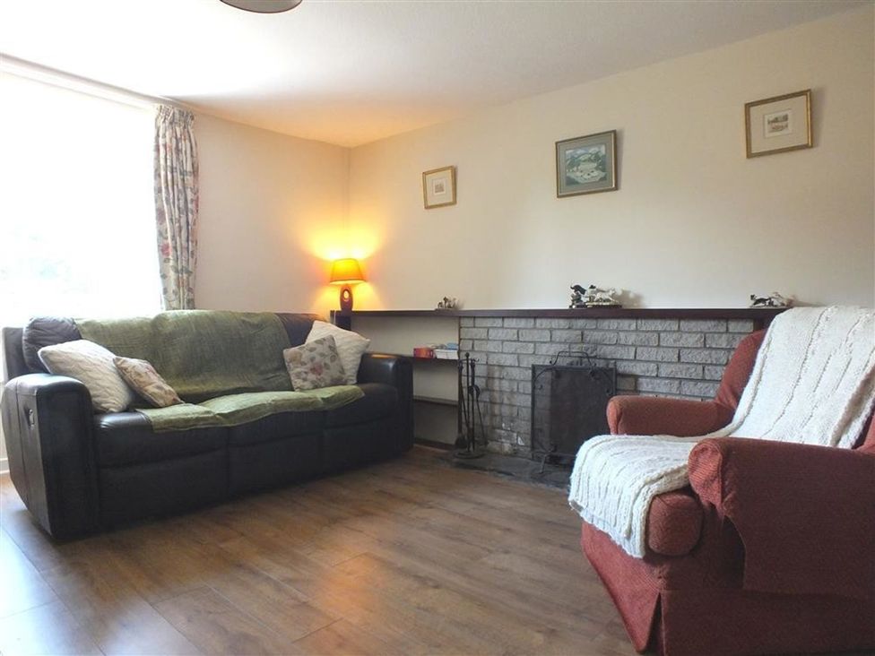 A living room with a sofa and armchair at Dinas Island Cottage Dinas Cross