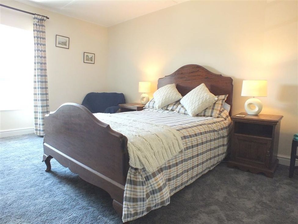 A bedroom with a bed and bedside table at Dinas Island Cottage Dinas Cross