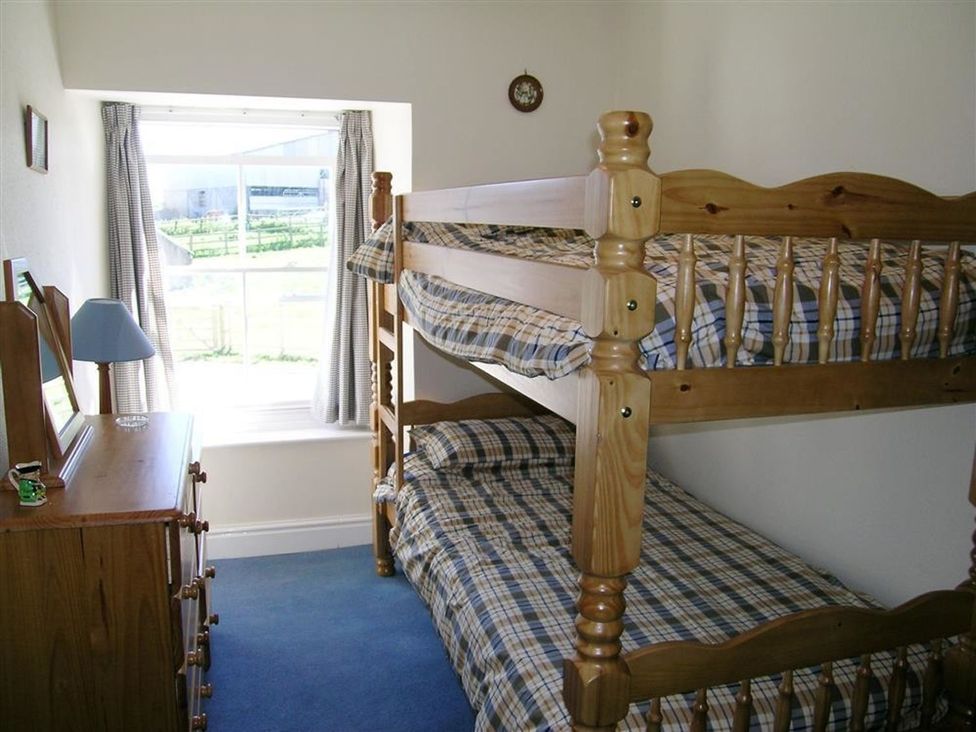 A bedroom with a bunk bed and a dresser at Dinas Island Cottage Dinas Cross