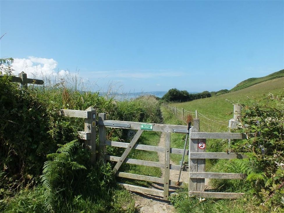 A gate leading to a pathway in an outdoor area at Dinas Island Cottage in Dinas Cross