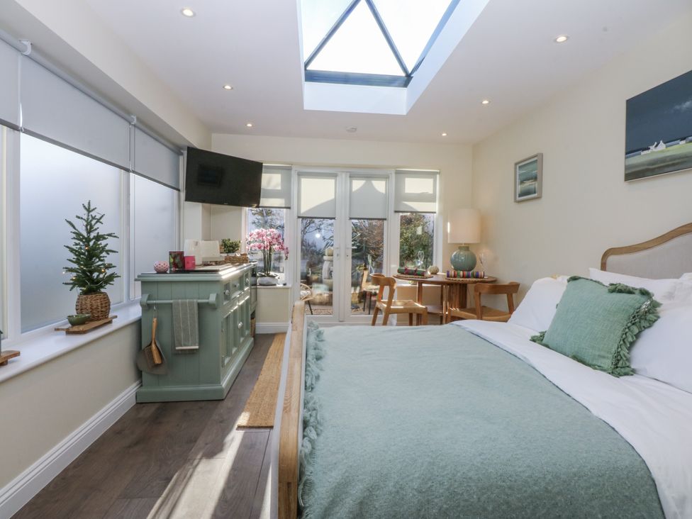 A bedroom with a bed and television at The Summerhouse in Llandudno
