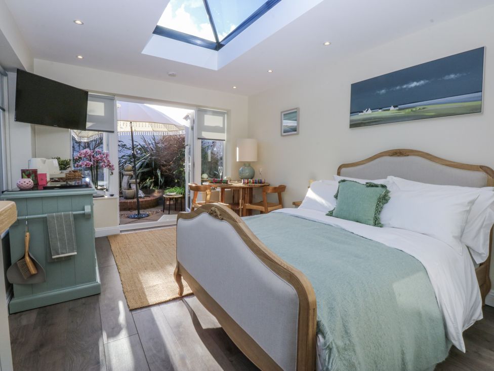 A bedroom with a bed and television at The Summerhouse in Llandudno