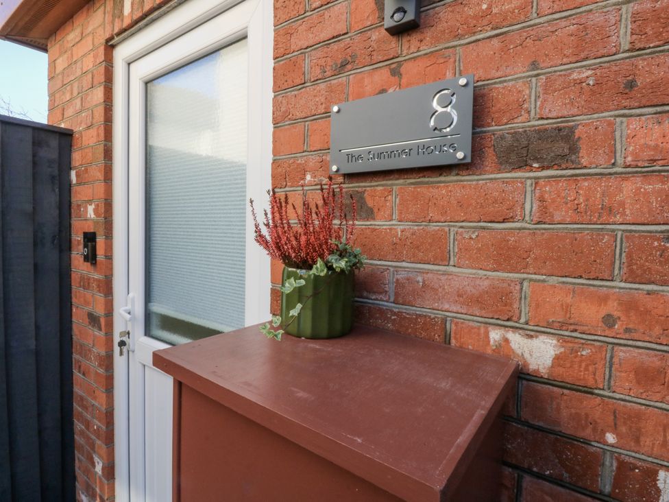 An exterior view with a door and sign at The Summerhouse in Llandudno
