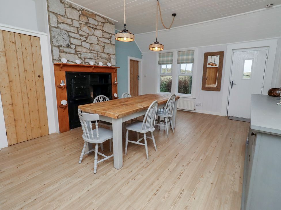 A dining room with a wooden table and chairs at Braeburn in Bamburgh