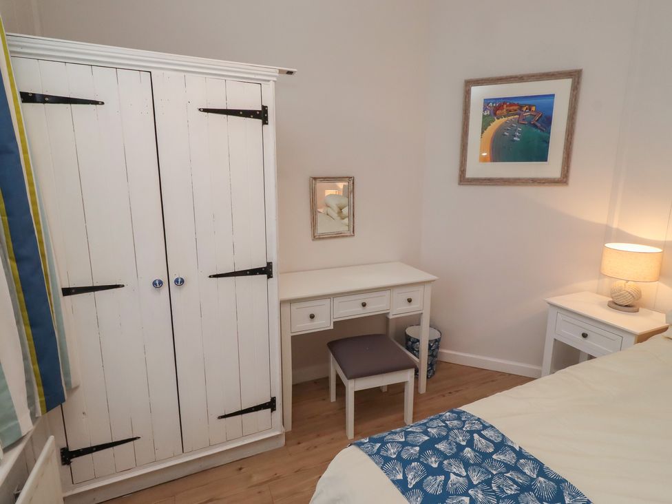 A bedroom with a wardrobe and desk at Braeburn in Bamburgh