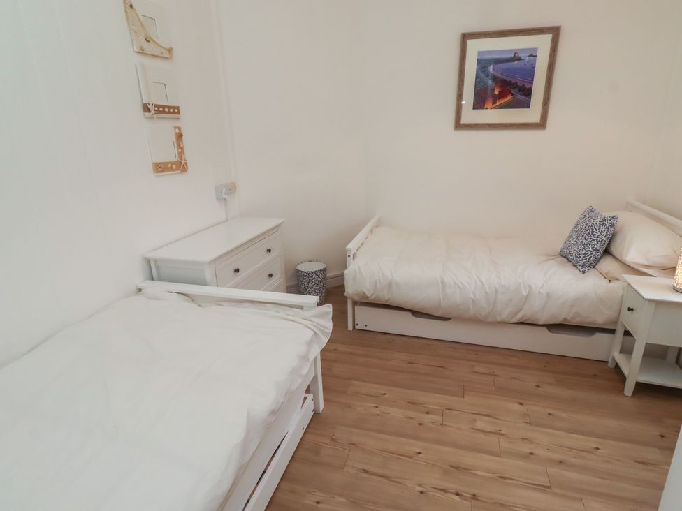 A bedroom with two beds and a nightstand at Braeburn in Bamburgh
