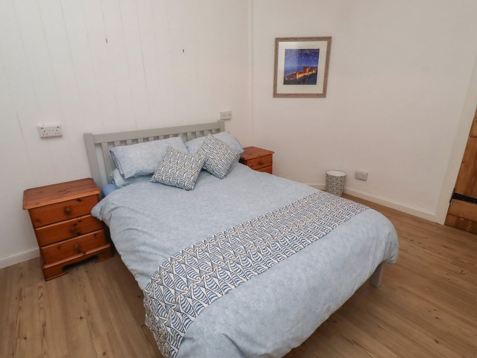 A bedroom with a bed and nightstands at Braeburn in Bamburgh