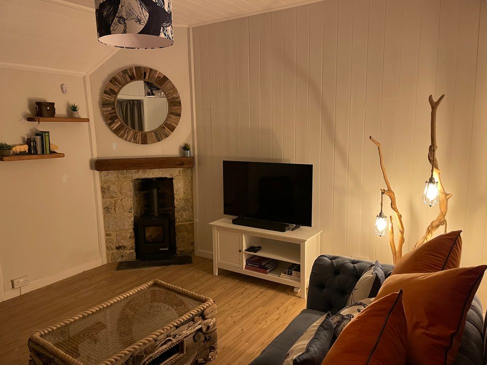 A living room with a sofa and television at Braeburn in Bamburgh