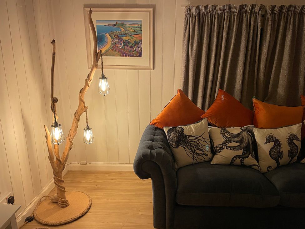 A living room with a sofa and decorative pillows at Braeburn in Bamburgh