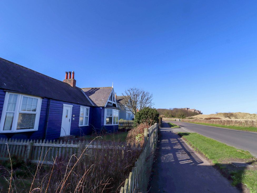 A purple house with a fence and road at Braeburn in Bamburgh