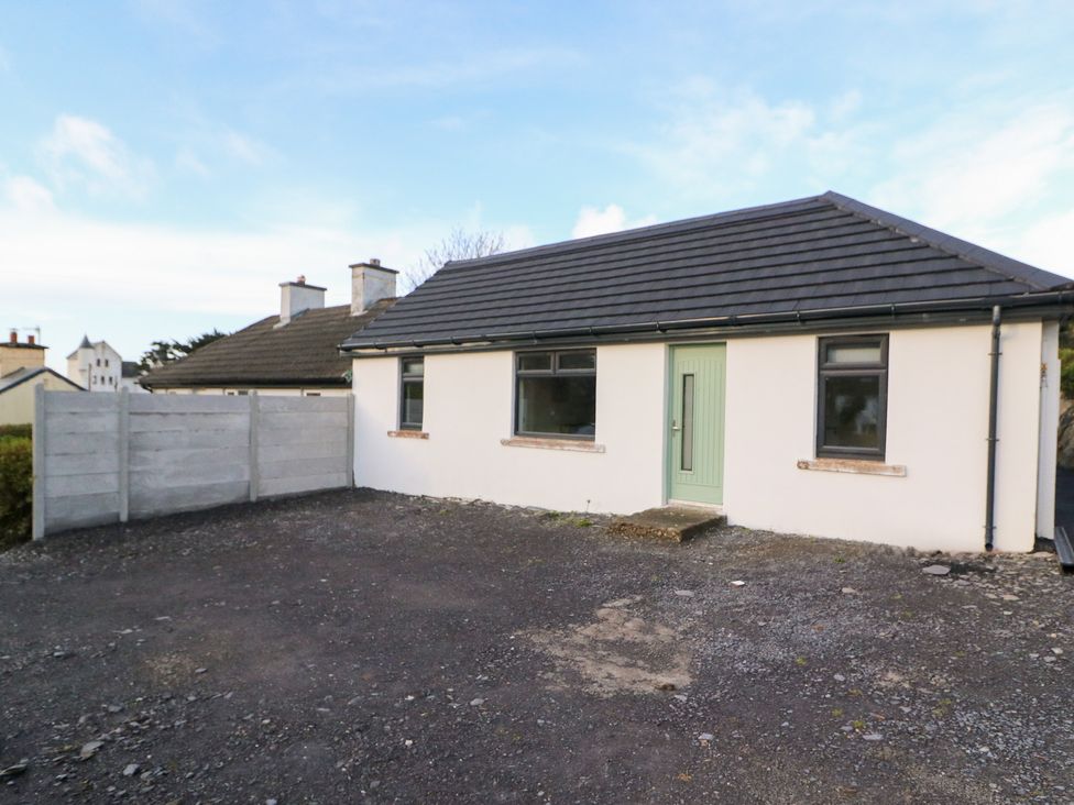 A house with a green door and windows in an outdoor area at Duck Cottage