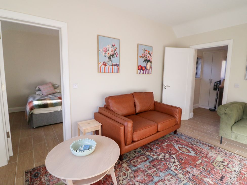 A living room with a sofa and side table at Duck Cottage