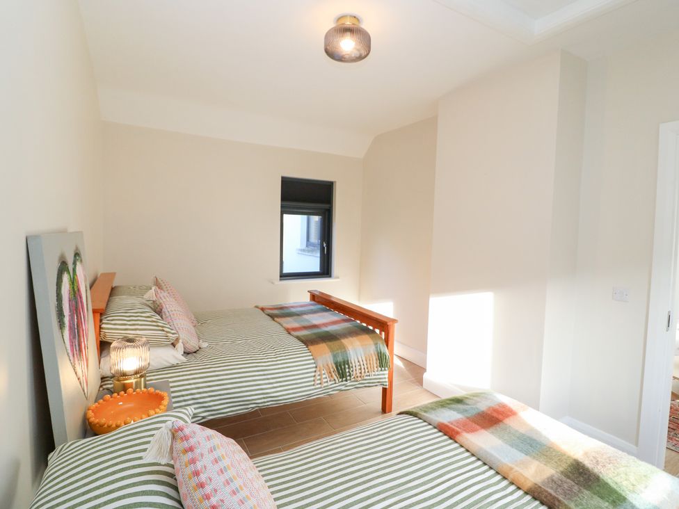 A bedroom with two beds and a window at Duck Cottage