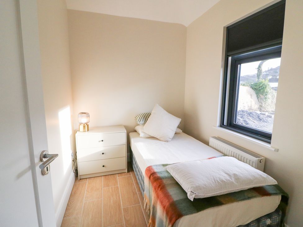 A bedroom with a bed and a bedside table at Duck Cottage