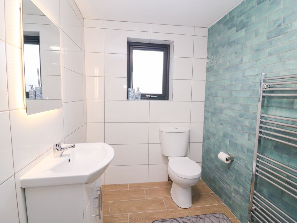A bathroom with a sink, toilet, and towel rack at Duck Cottage