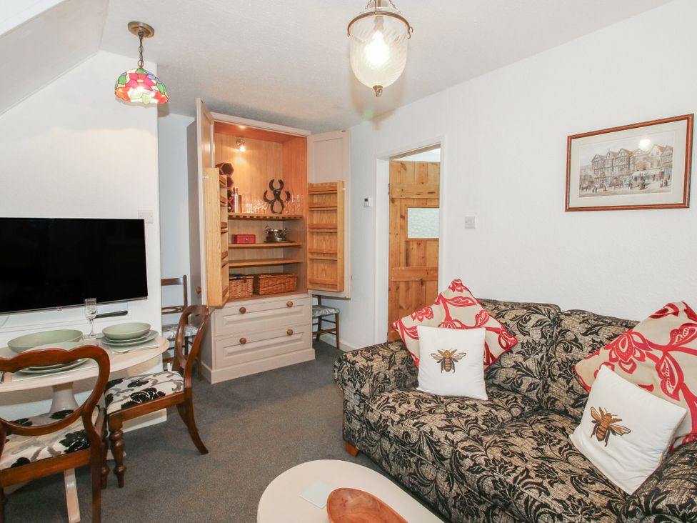 A living room with a sofa and dining area at Bumble Bee at 2 Clematis Cottage near Clee Hill