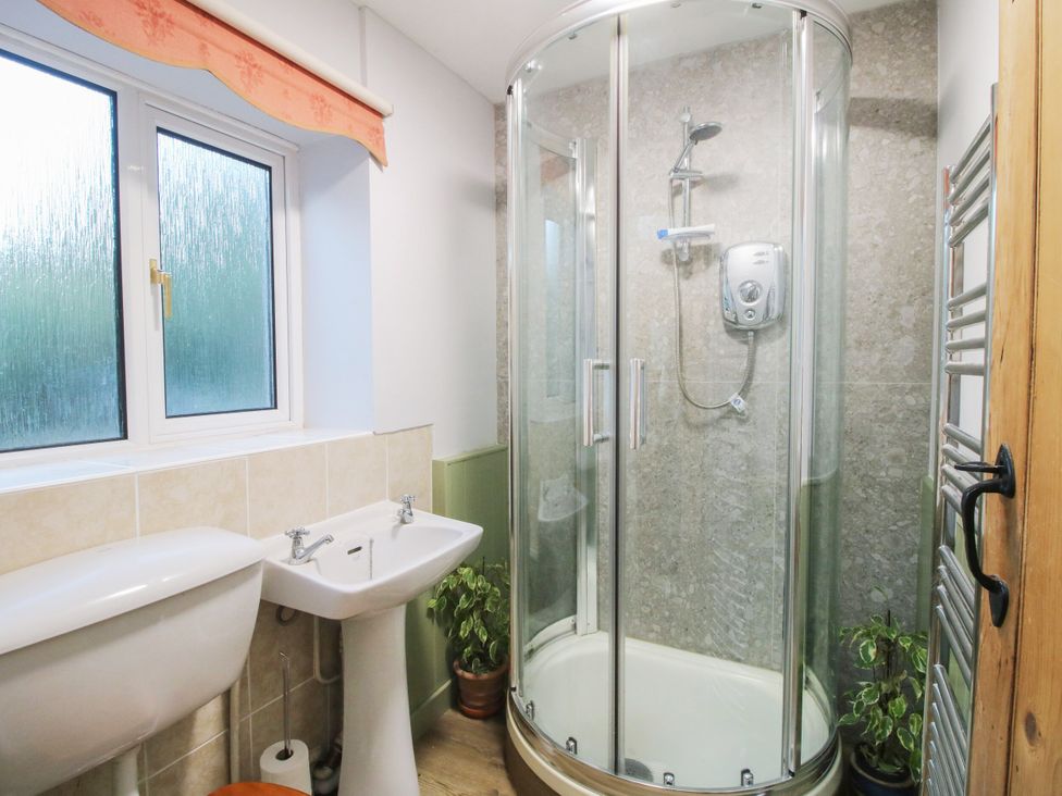 A bathroom with a shower, toilet, and sink at Bumble Bee at 2 Clematis Cottage near Clee Hill