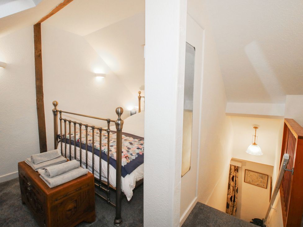 A bedroom with a bed and stairs at Bumble Bee at 2 Clematis Cottage near Clee Hill