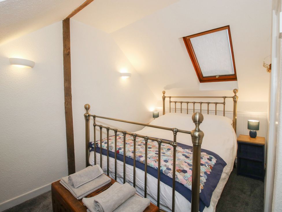 A bedroom with a bed and nightstand at Bumble Bee at 2 Clematis Cottage near Clee Hill