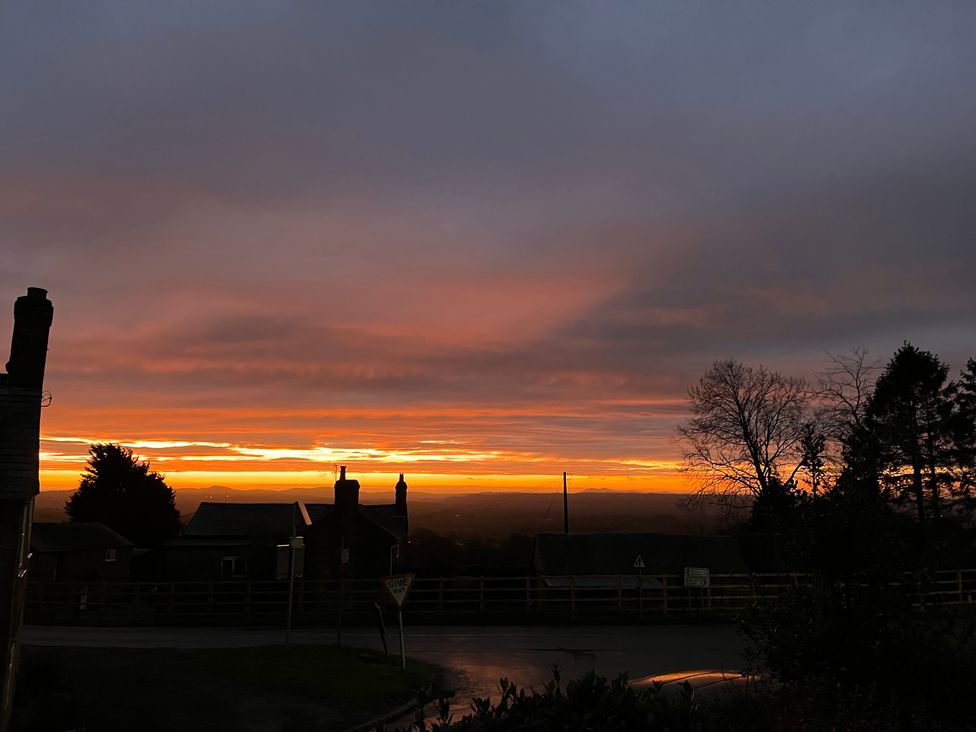 A sunset view with trees and houses near Clee Hill at Bumble Bee at 2 Clematis Cottage
