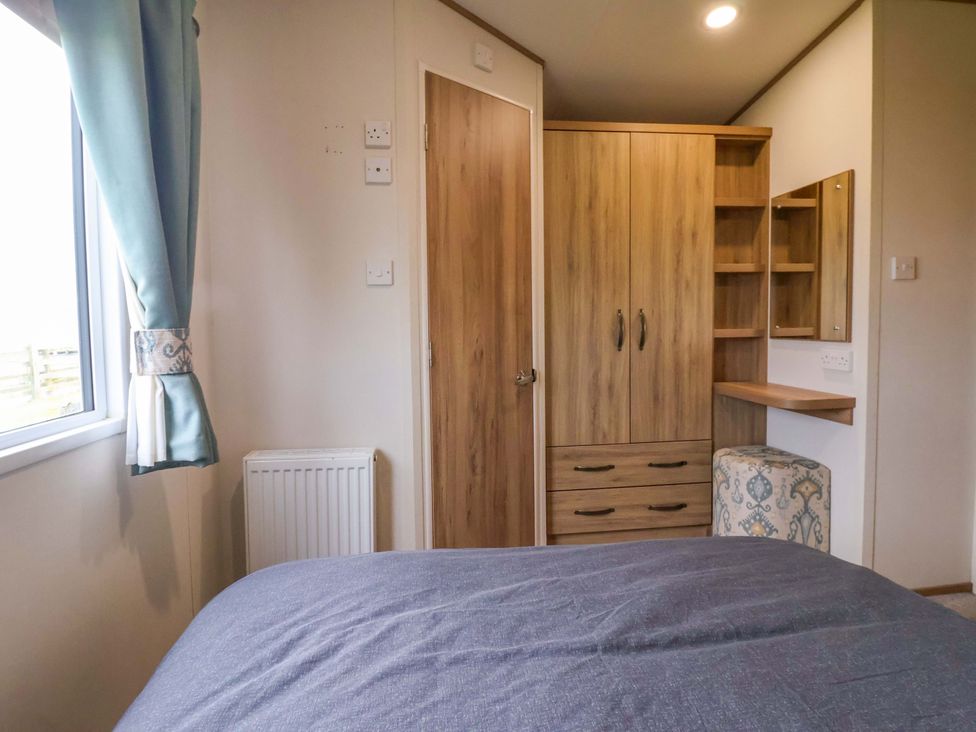 A bedroom with a bed, window, and wardrobe at The Drift in High Skirlington near Skipsea