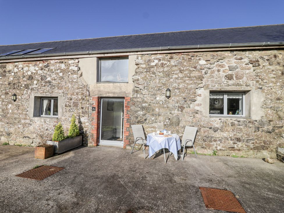 An outdoor area with a table and chairs at Dairy Cottage Bullhornstone near South Brent