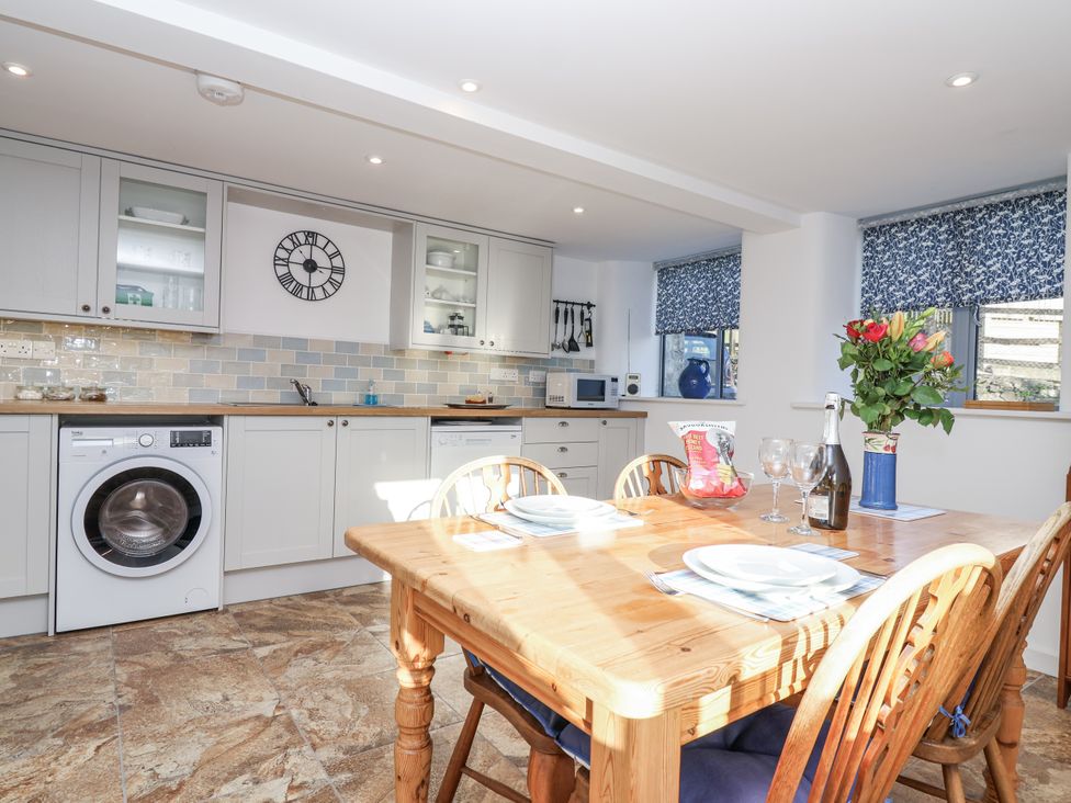 A kitchen with a dining table and chairs at Dairy Cottage Bullhornstone near South Brent