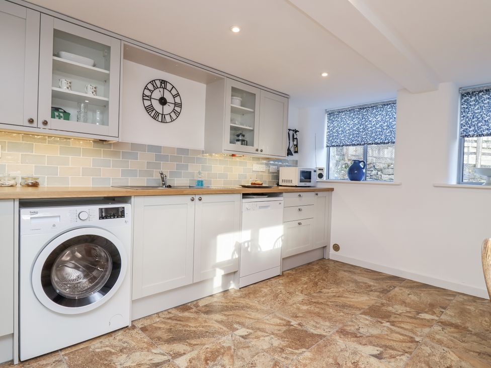 A kitchen with appliances and cabinets at Dairy Cottage in Bullhornstone near South Brent